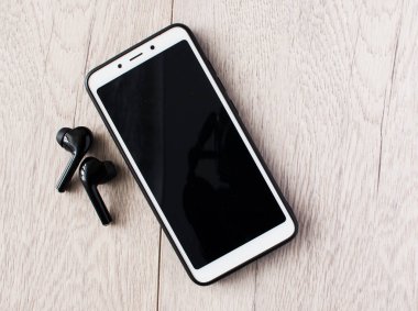 Akıllı telefon ve kulaklık üzerinde ahşap masa