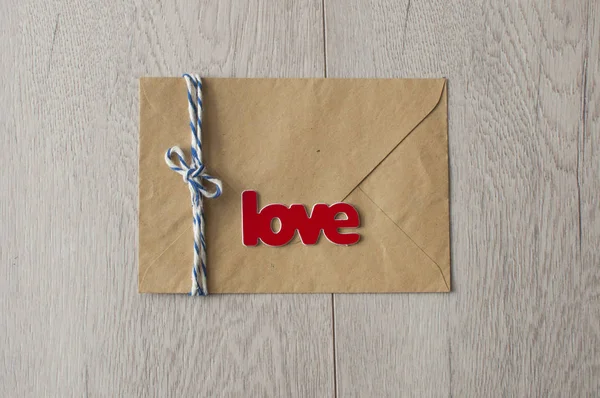 Brown color envelope and word love with wax seal on white wood — 스톡 사진