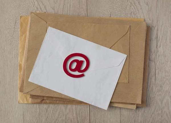 Símbolo de e-mail no sinal no fundo envelopes marrom — Fotografia de Stock