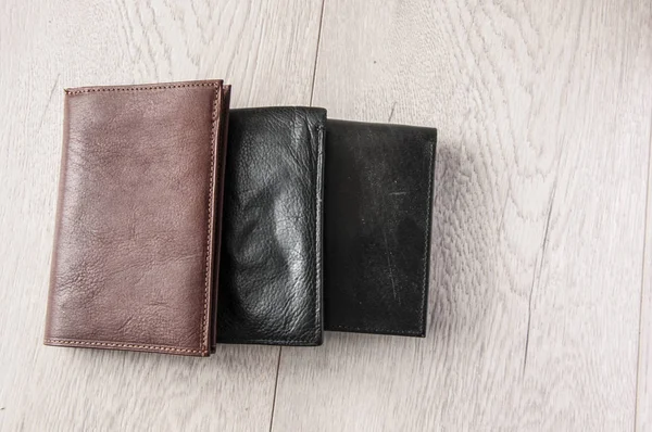 Three leather wallets on wooden table — Stockfoto