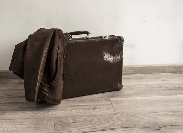 De leren jas zit op een oude koffer in de kamer met wit — Stockfoto