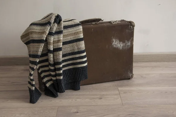 Мужской свитер на старом чемодане в номере — стоковое фото