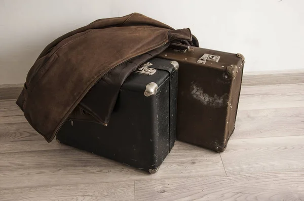 Läderjackan är på en gammal resväska i rummet med vit — Stockfoto
