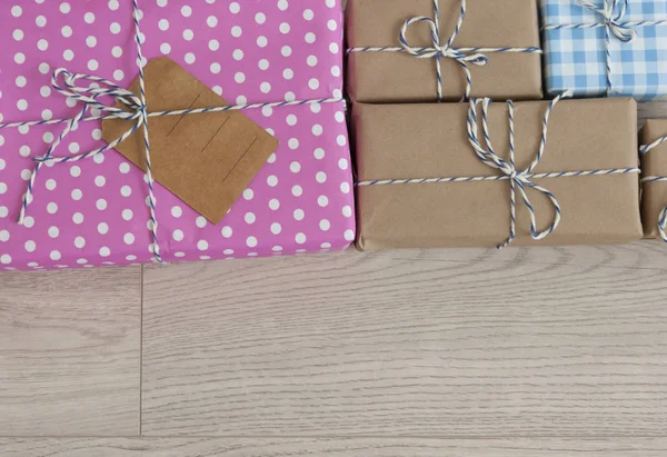 Schachtelattrappen für Geschenke aus Kraftpapier auf Holzgrund. — Stockfoto