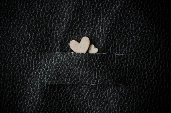 Fondo del Día de San Valentín. Dos corazones de madera en cuero negro b —  Fotos de Stock