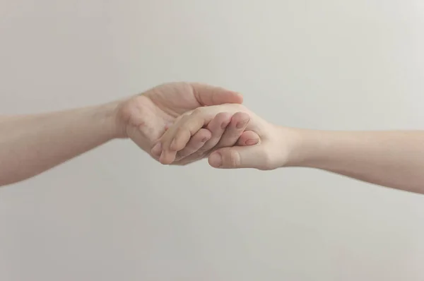 Erwachsener hält Baby Hand über weißem Wandhintergrund — Stockfoto