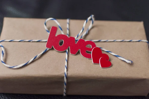 Caja envuelta con un regalo en papel artesanal marrón y atado — Foto de Stock