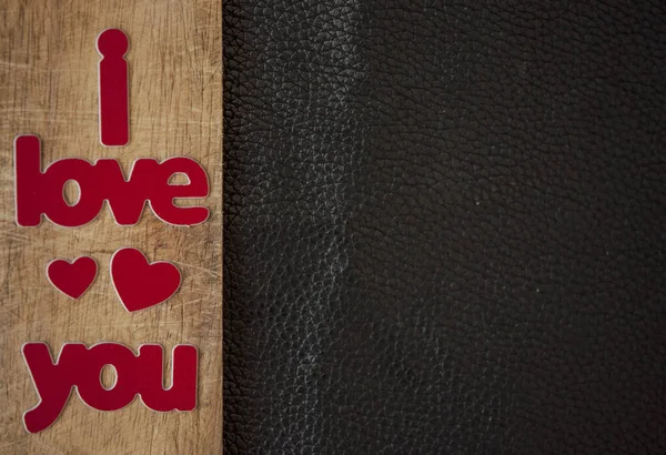 Tarjeta de San Valentín. Palabra Amor con corazones rojos en respaldo de madera — Foto de Stock