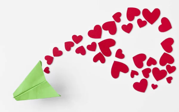 Valentijnsdag achtergrond. Papier vliegtuig met rood hart vliegen op — Stockfoto