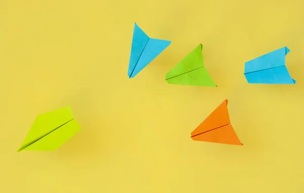 Papier vliegtuigen op kleurrijke papieren achtergrond, Business competitie — Stockfoto
