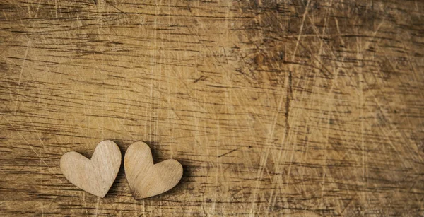 Dvě dřevěná srdce umístěna pěkně na vinobraní dřeva pozadí — Stock fotografie