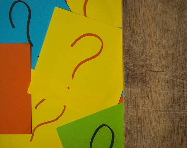 Pila di carte colorate con un punto interrogativo sul vecchio b di legno — Foto Stock
