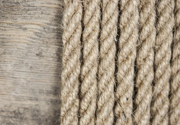 太い麻ロープのクローズアップ 古い木製のテーブルの上に天然ロープ サイドビュー ソフトフォーカス — ストック写真