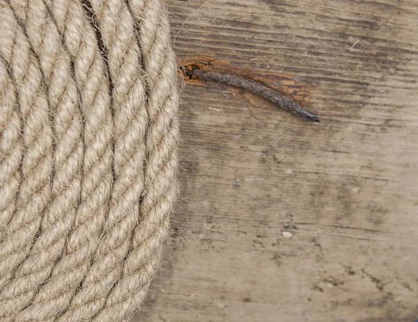 Close-up of a thick hemp rope. Natural rope on an old wooden table. Side view. Soft focus.