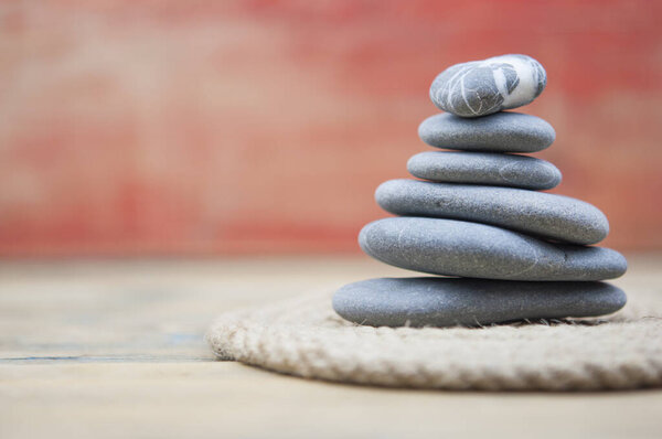 balancing pebbles with hemp rope on wooden table, space for text. Zen concept