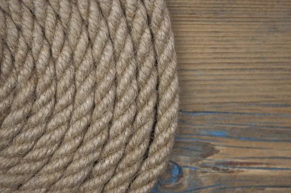 太い麻ロープのクローズアップ 古い木製のテーブルの上に天然ロープ サイドビュー ソフトフォーカス — ストック写真