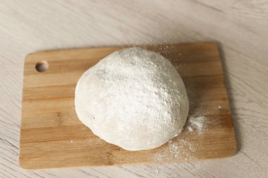 Ahşap kesim tahtası yemek fotoğrafçılığı fikrine un sürülmüş hamur. 