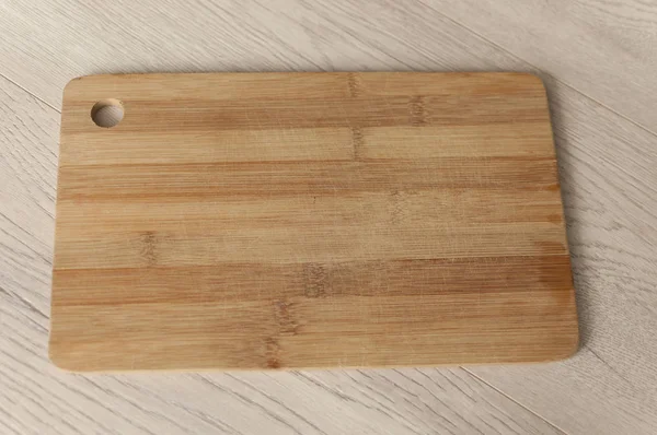 top view of wooden cutting board on white tabletop. Food background concept