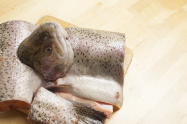 Tahta bir yüzeyde taze alabalık parçaları.