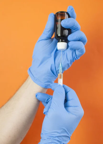 青い手袋の手に注射器付きの医師保持ボトル 薬局研究所インフルエンザの概念 ビタミン注射器ガラス瓶 看護師の治療 — ストック写真