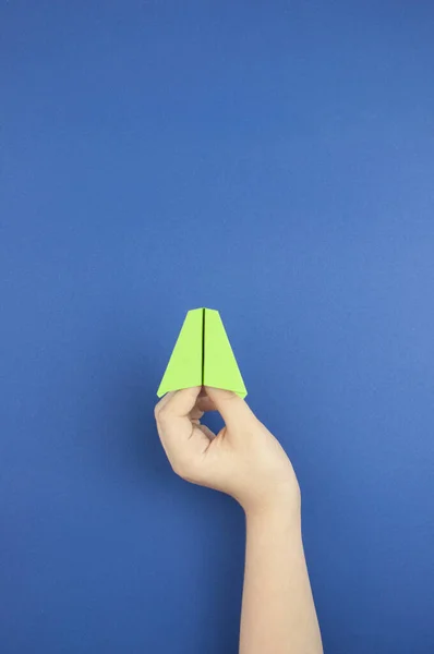 青い色の背景にテキストのためのスペースを持つ飛行機の手保持紙モデル — ストック写真
