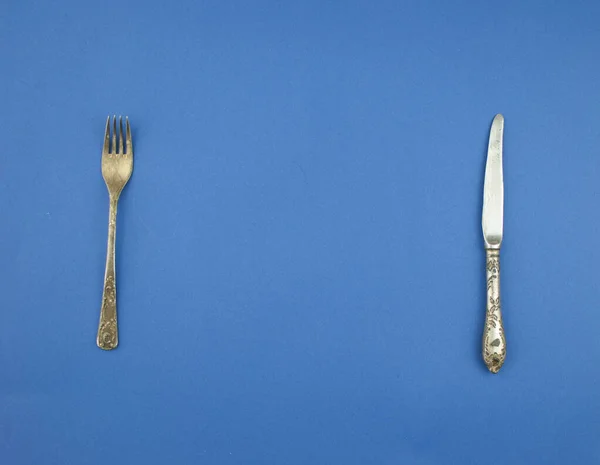フォークとナイフ青の背景にコピースペース — ストック写真