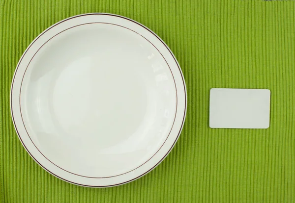 Top View Ceramic Plate Empty Label Green Tablecloth — Stock Photo, Image