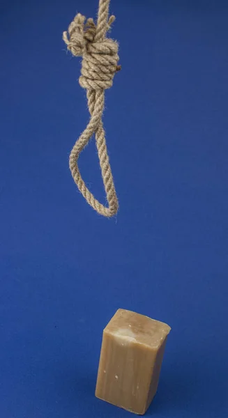 ループと青の背景に茶色の石鹸でロープ ハングマンの鼻でロープを 自殺の概念 — ストック写真