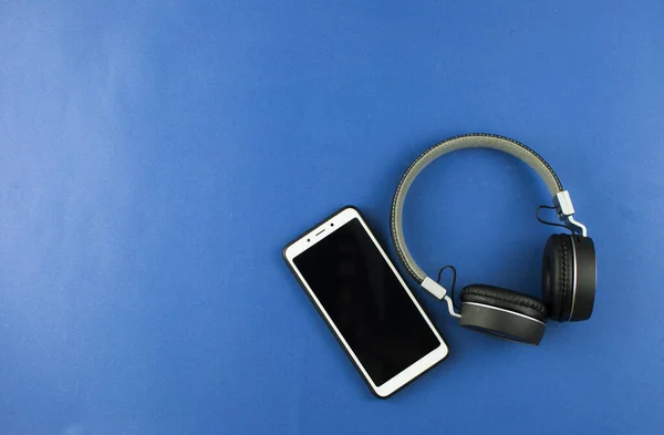 Top View Headphones Smartphone Blue Background Minimalist Photo Earphones Copy — Stock Photo, Image