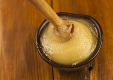 Ballı çömlekten bal damlıyor. Yakın plan. Ahşap bal kaşığından batırılan sağlıklı organik bal, yakın plan. Tatlı tatlı geçmişi