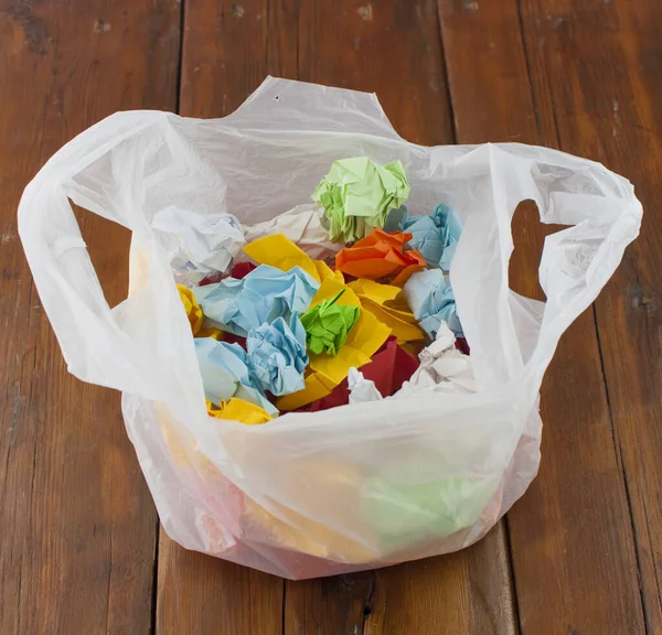 Çöp Torbası Plastik Ahşap Zeminde Renkli Buruşuk Kağıtlar — Stok fotoğraf