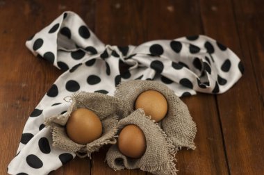 Kırsal ve doğal bir Paskalya. Çuval bezi ve ahşap bir zemine yerleştirilmiş Paskalya yumurtalarının düz kompozisyonu, yazı için boşluk. Mutlu Paskalya Bayramı Kutlama Kartı. 