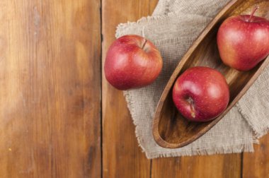 Tahtadaki kasede olgun organik sağlıklı elmalar. Sağlıklı yemek.