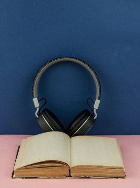 Kopya alanı olan boş bir kitap sayfası olan kulaklıklar. Uzaktan eğitim kavramı