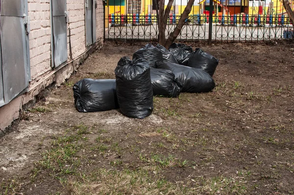 用黑色塑料袋装垃圾 清扫街道 — 图库照片