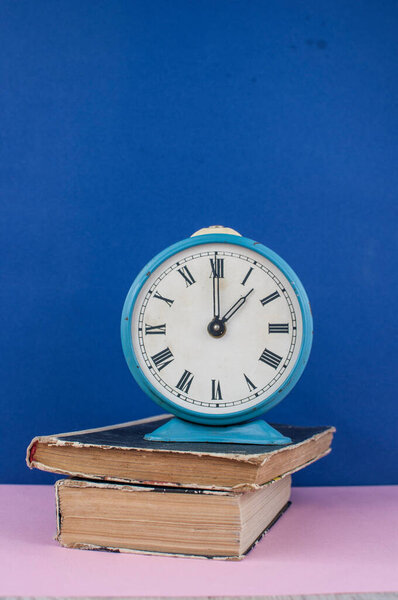 vintage alarm clock on light blue background. Space for text
