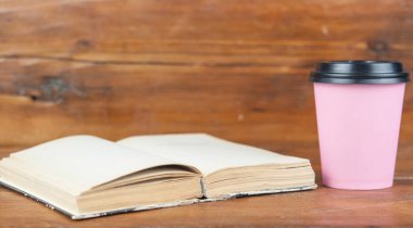 Bir fincan kahve ve kitap masanın üstünde..