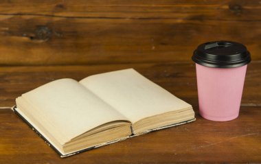 Bir fincan kahve ve kitap masanın üstünde..