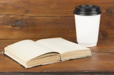 Bir fincan kahve ve kitap masanın üstünde..