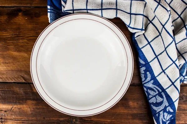 棕色木制桌子上有餐巾的空盘子 — 图库照片