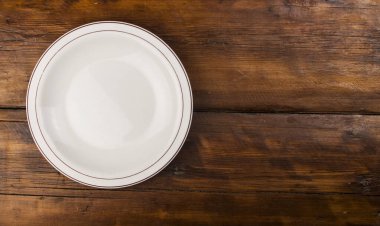 Beyaz tabak tahta zeminde duruyor.