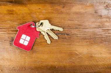 Eski ahşap arka planda altın anahtarlı evin sembolü 