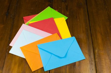 Renkli zarflar eski ahşap masanın üzerinde duruyor.  