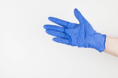 Doktor, steril eldivenler içinde beyaz duvar arka planında işaret var. Salgın, güvenlik