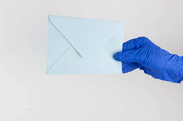 Una Mano Guanto Medico Blu Tiene Una Busta Uno Sfondo — Foto Stock