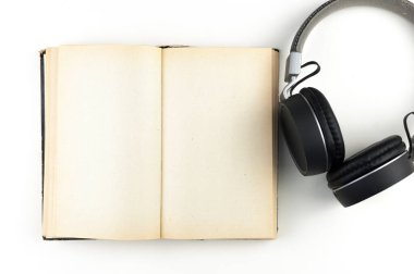 Ses kitabı konsepti. Beyaz arka planda kitap olan kulaklıklar. Kitap dinliyordum. Modern eğitim.