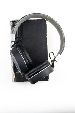 Ses kitabı konsepti. Beyaz arka planda kitap olan kulaklıklar. Kitap dinliyordum. Modern eğitim.