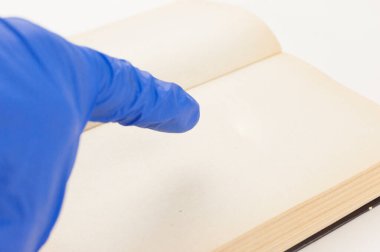 Tıbbi bir eldiven ve açık bir kitap verin. Metnin için boşluk kopyala