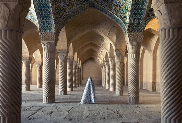 Mujer con velo entre columnas talladas de la mezquita Vakil en Shiraz —  Fotos de Stock