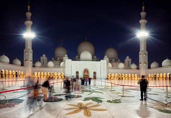 Vierailijat saapuvat Zayedin suureen moskeijaan Abu Dhabissa Emiraattien hämärässä — kuvapankkivalokuva